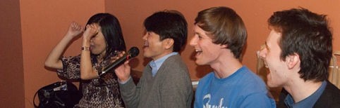 Four people singing karaoke