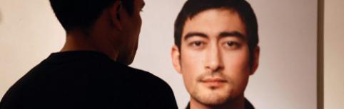 A man looking at a photo of a half Japanese man