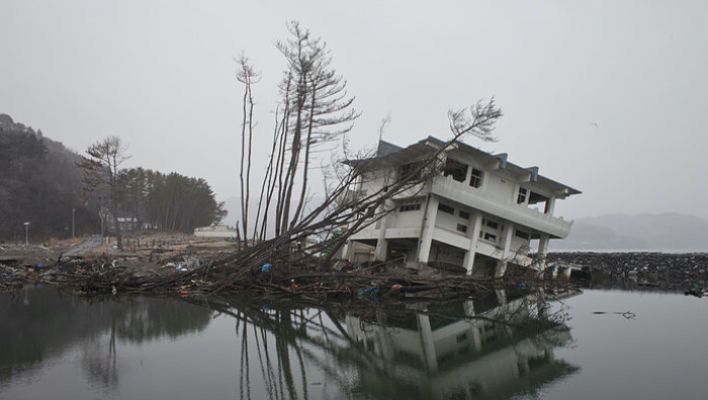 A house near a lake damaged by an earthquake