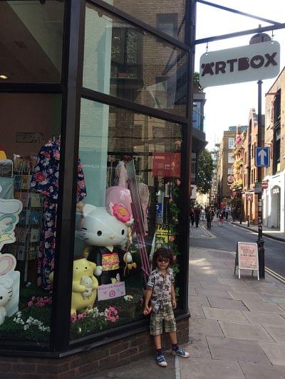 A child standing outside a stationery shop