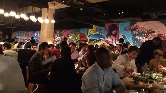 People sitting at tables in a restaurant having dinner