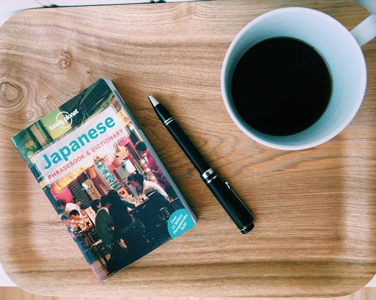 A book and a cup of coffee on a tray