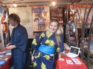 A man and a woman standing at a Japanese themed stall