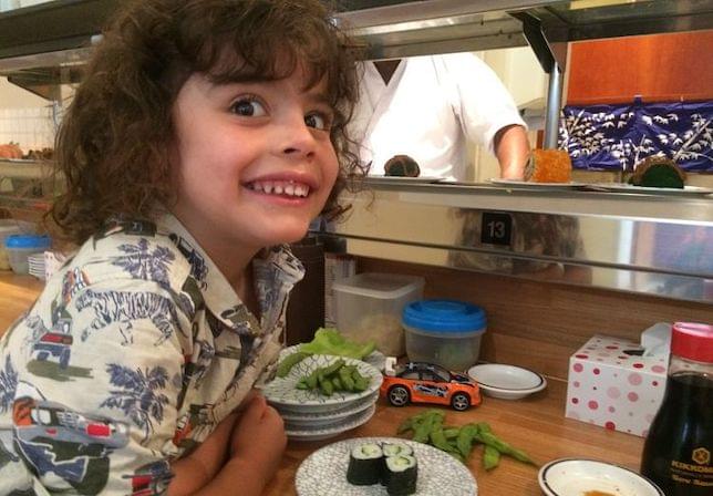 A boy in a sushi restaurant