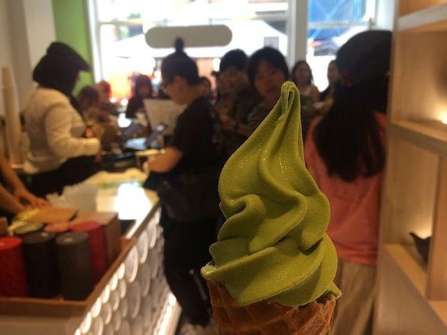 Someone holding a Matcha ice-cream in a cafe