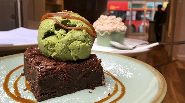 Some cakes and ice cream on plates in a restaurant