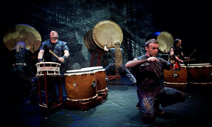 A group of drummers performing on a stage