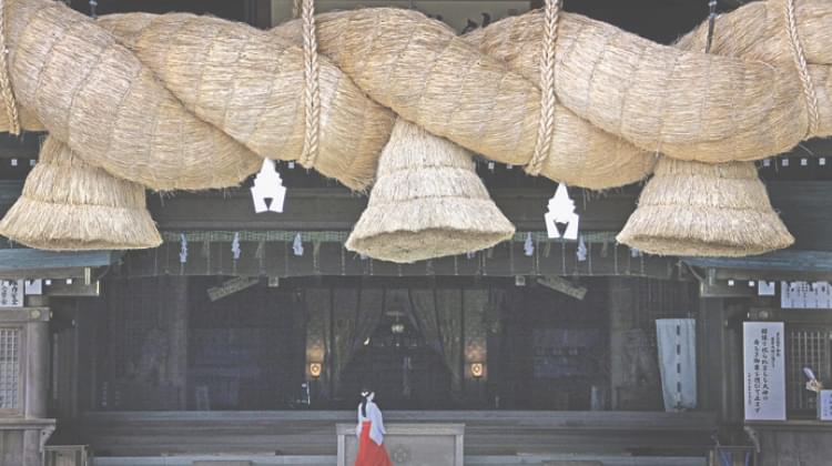 A huge rope with bells made of rope hanging from a ceiling