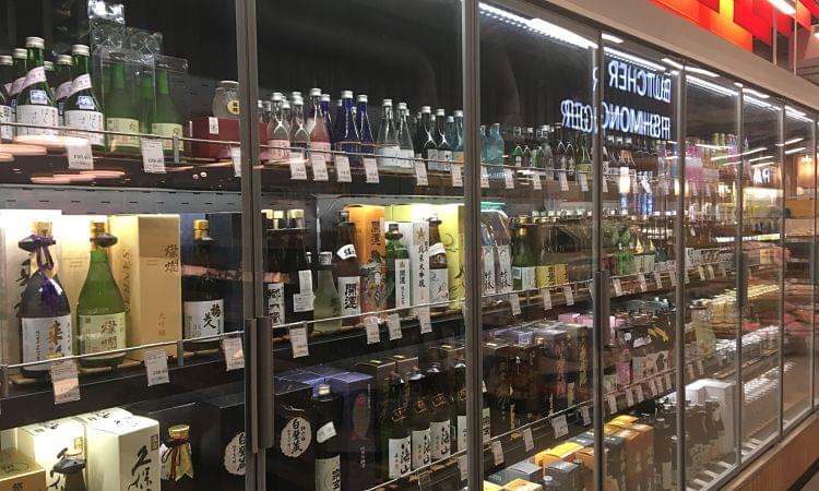 A huge display fridge full of bottles of Saki