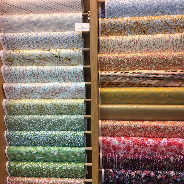 a selection of Japanese decorative paper displayed on a rack