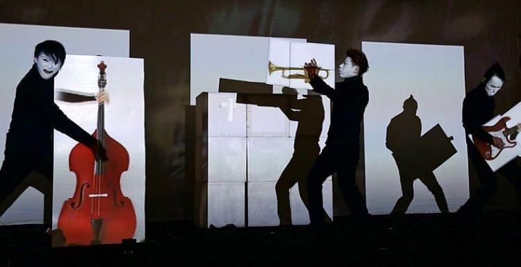 Three Japanese people playing musical instruments on stage