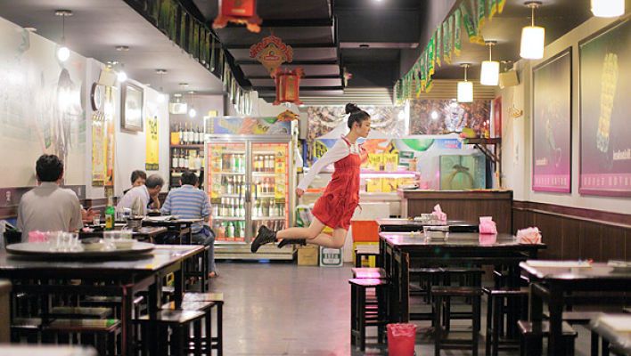 A woman appearing to float in the air in a restaurant