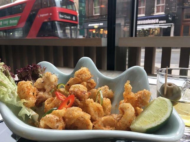 Some squid in a bowl with a London street and bus in the background