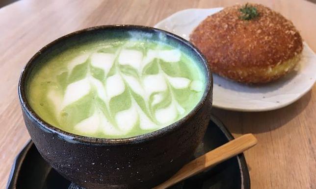 A matcha latte drink and a cake on a table