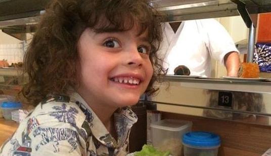 A young boy smiling a restaurant smiling