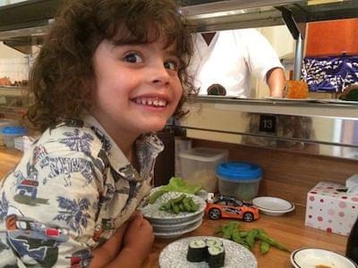 A smiling young boy in a cake shop