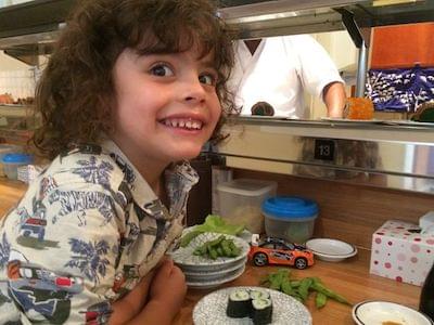 A smiling young boy in a cake shop